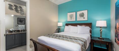 A bedroom with a bed, nightstands, a ceiling fan, and artwork on the walls.