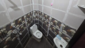 A small, tiled bathroom with a toilet, bidet, and shower. - Peaceful 1BHK 🌿 WiFi near by GT Mall, Airport” ✅ Jawahar circle malviya nagar (Jaipur)
