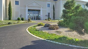 A building with a large entrance, a driveway, and landscaped gardens. - Terres de France - Domaine Val d'Amboise (Amboise)