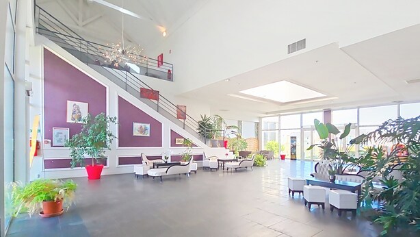 A spacious lobby with a staircase, seating area, and large windows. - Terres de France - Domaine Val d'Amboise (Amboise)