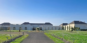 A large building with a central courtyard, surrounded by a well-maintained lawn and a paved walkway.