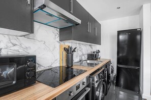 Eine moderne Küche mit Mikrowelle, Toaster, Spüle und Edelstahlgeräten.