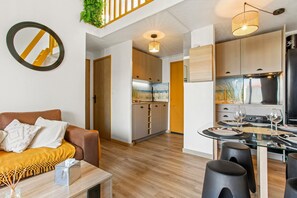 Ein modernes Apartment mit Wohnzimmer, Küche und Essbereich.