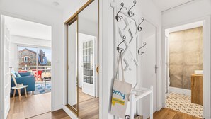 An open door leading to a living area with a blue sofa, a small table, and a view of a building outside. - Accommodation for 4, 500m from the beach (Dinard)