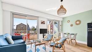 A modern living room with a sofa, chairs, a coffee table, and a dining area with a table and chairs. - Accommodation for 4, 500m from the beach (Dinard)