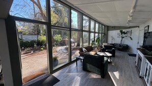A spacious office with large windows, a modern interior, and a view of the outdoors.