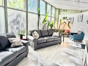 A modern living room with leather sofas, a coffee table, and large windows with blinds. - 5 king beds, near UofO, Hayward Field, Matthew Knight arena and Autzen! š (Eugene)
