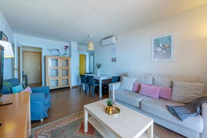 Ein Wohnzimmer mit einer Couch, einem Couchtisch und einem Essbereich mit Stühlen und einem Tisch.