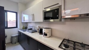 Eine moderne Küche mit Gasherd, Mikrowelle und Kaffeemaschine.