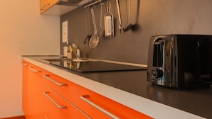 Une cuisine équipée d’un grille-pain, d’un évier et d’ustensiles de cuisine suspendus.
