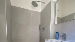 A modern bathroom with a shower, toilet, and vanity.