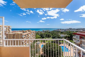 A balcony with a view of a swimming pool, a cityscape, and the sea. - Renovated apartment with beautiful views in Iris (Benalmádena)