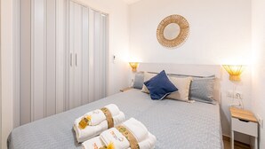Une chambre à coucher avec un lit, des lampes de chevet, un miroir et une armoire.