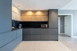 A modern kitchen with built-in cabinets, a microwave, and a coffee machine. - LAPAELLA 2- Contemporary oceanfront apartment (Torremolinos)