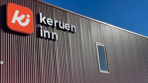 Un bâtiment à l’extérieur vertical et strié, avec un logo et une enseigne bien visibles.