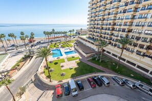 A high-rise hotel with a pool area, parking, and a view of the sea. - Studio in aloha with front ocean view (Benalmádena)