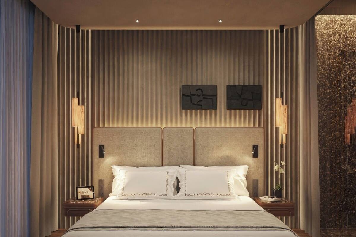 Une chambre à coucher moderne avec un grand lit, des tables de chevet et une tête de lit dotée d’un éclairage intégré.