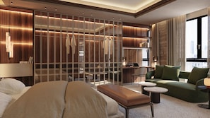 Una habitación de hotel moderna con una cama grande, una zona de estar con un sofá y sillones, un escritorio con una computadora portátil y un vestidor con ropa.