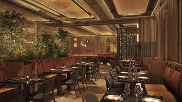 A restaurant with wooden booths, black marble tables, and a warm ambiance.