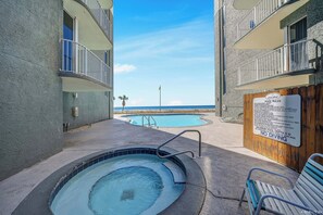 A pool area with a hot tub, a wooden fence with pool rules, and a view of the ocean. - FREE Beach Service, Long Beach IV 707E Pools, Hot Tub, Gym, FREE Golf & Perks (Panama City Beach)