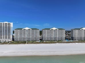 A beachfront hotel with multiple high-rise buildings, a sandy beach, and a clear blue sky. - FREE Beach Service, Long Beach IV 707E Pools, Hot Tub, Gym, FREE Golf & Perks (Panama City Beach)