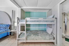 A bunk bed with a lower bunk, a bedside table, a mirror, and a shower area. - FREE Beach Service, Long Beach IV 707E Pools, Hot Tub, Gym, FREE Golf & Perks (Panama City Beach)
