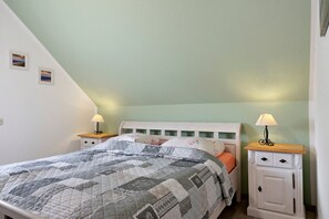 Ein Schlafzimmer mit einem Bett, zwei Nachttischen und einem Schrank.