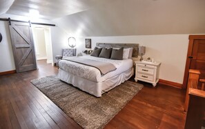 Une chambre à coucher avec un lit, une table de chevet et une porte.