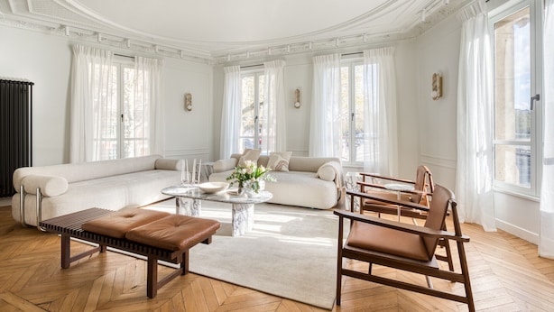 Un salón amplio con un sofá grande, una mesa de centro y un banco.