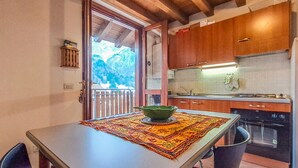 Una cocina con armarios de madera, una estufa y una ventana con vistas a un paisaje montañoso.
