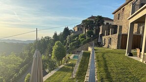 A residential area with stone buildings, a grassy lawn, and a pool. - Panoramic house, swimming pool, between langhe and monferrato (Castelletto d'Erro)