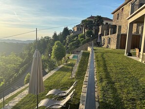 Zona residenziale con edifici in pietra, prato e piscina.