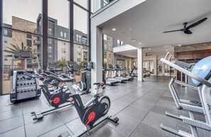 Een sportschool met hometrainers, loopbanden en krachtapparaten.