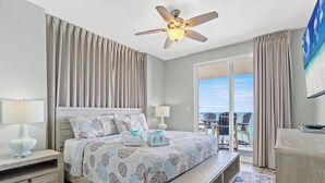 A bedroom with a bed, bedside tables, a ceiling fan, and a view of the outdoors. - TWO GULF-FRONT MASTERS - BEST 2br in Splash, End Unit, Included Beach Chairs! (Panama City Beach)