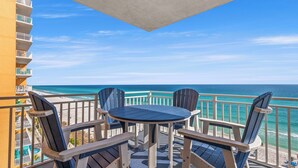 A balcony with a table and chairs, overlooking a beach and ocean. - TWO GULF-FRONT MASTERS - BEST 2br in Splash, End Unit, Included Beach Chairs! (Panama City Beach)
