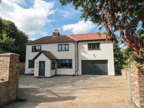 A two-story house with a garage, a small attached garage, and a gravel driveway. - Riverside House (Scarborough)