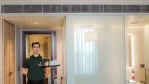 A hotel room with a modern design, including a glass partition, a minibar, and a clean, well-lit space. - Ramee Collection Airport Road Mohali (Mohali)
