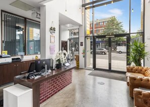 A reception area with a desk, computer, and a plant. - Student Only Bronze Ensuite at Highbury  (London)