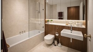A modern bathroom with a glass-enclosed shower, a white bathtub, a toilet, and a vanity with a sink and mirror. - Cozy 2-Bed in Central London (London)