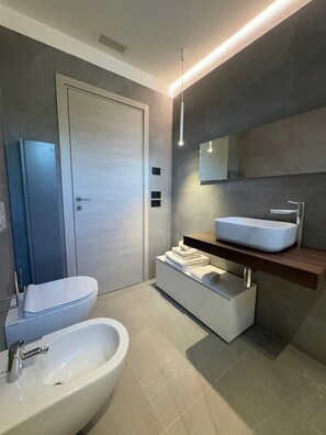 Ein modernes Badezimmer mit Toilette, Bidet und Waschtisch.