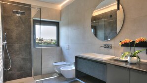 A modern bathroom with a glass shower enclosure, a toilet, a sink, and a large mirror. - Aria Art Suite   Lake View Terrace and Private Hot Tub (BARDOLINO)