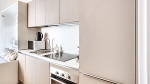 Een moderne keuken met een ingebouwde kookplaat, een spoelbak en een koffiezetapparaat.