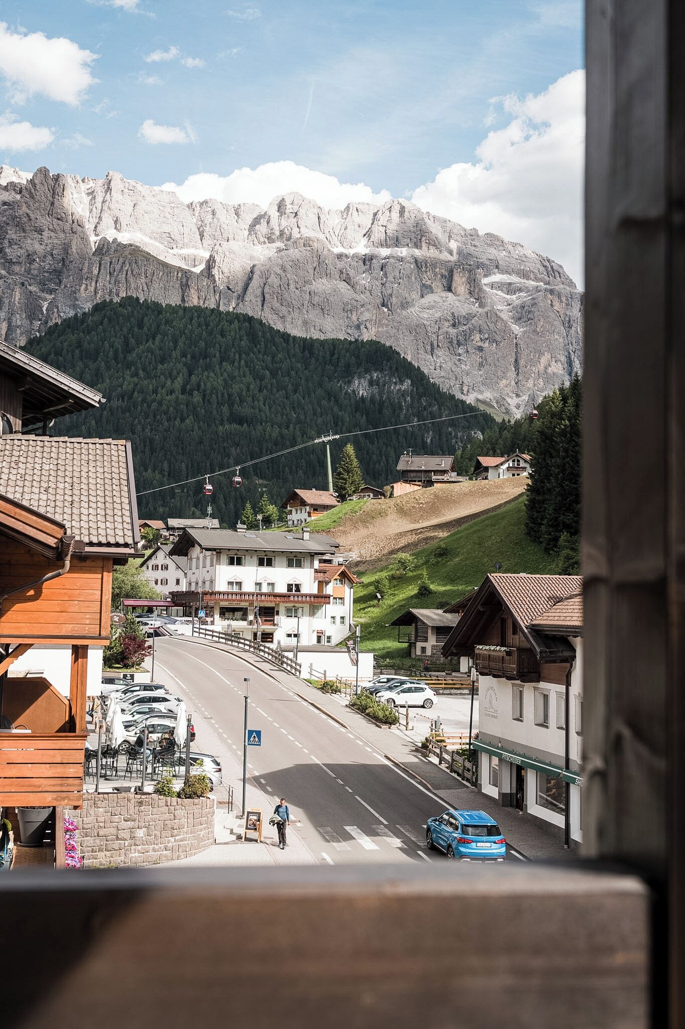 A mountain town with buildings, a road, and a ski lift.