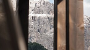 A room with a view of a mountainous landscape through a window. - Hotel La Truga (Selva di Val Gardena)