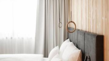 Quarto moderno com cama, painéis de madeira e luminária pendente.