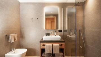 Un baño moderno con una bañera independiente, un tocador con espejo y una zona de ducha con paredes de vidrio.