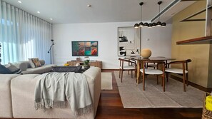 Una sala de estar moderna con un sofá, una mesa de centro y una zona de comedor con sillas.