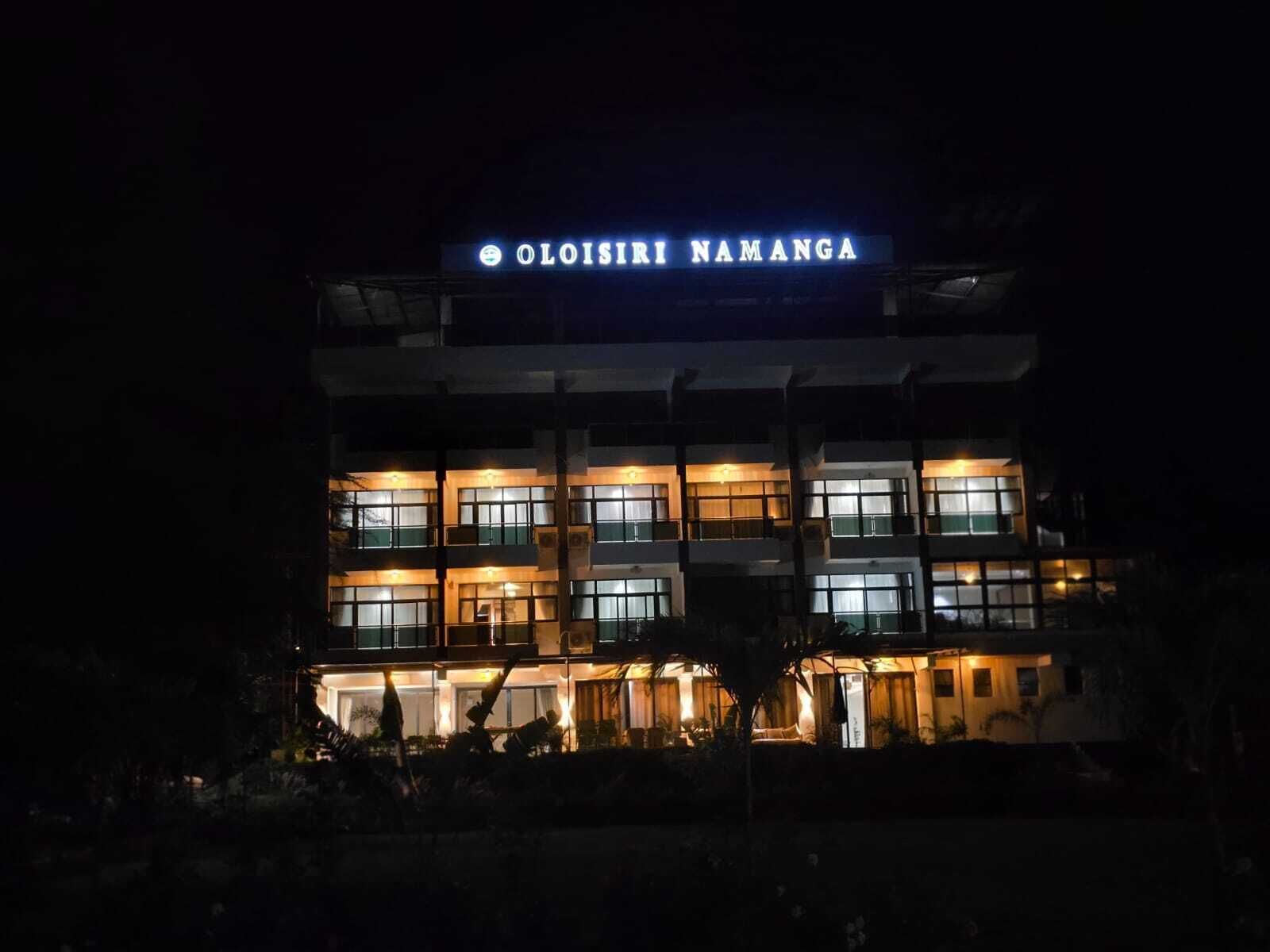 A multi-story building with illuminated signage reading 'Oloisir Namanga.'