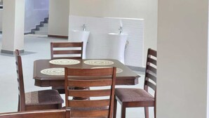 A dining area with a table, chairs, pendant lighting, and artwork on the walls. - OLOISIRI NAMANGA HOTEL (Namanga)