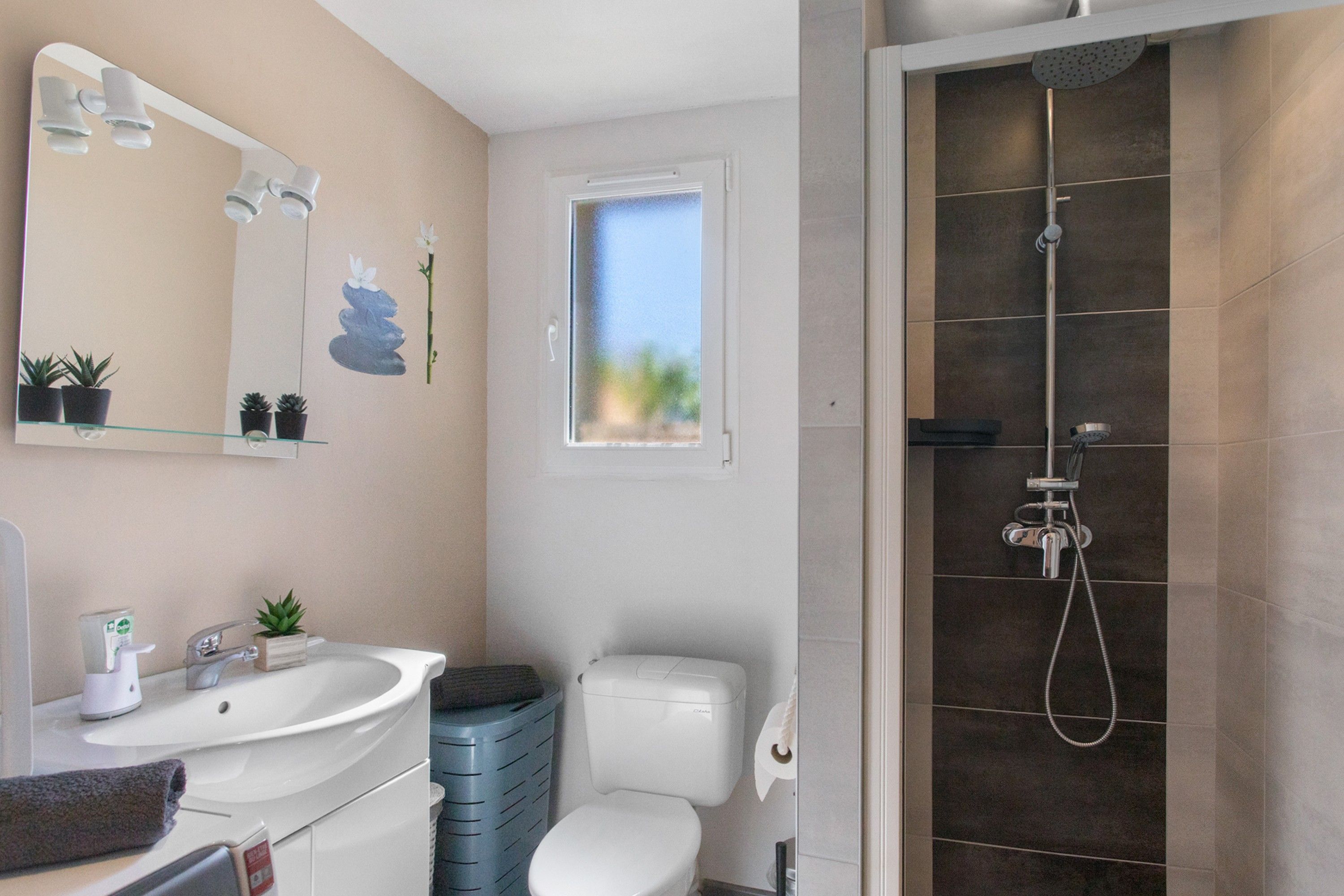Een badkamer met een wastafel, spiegel, toilet en douche.